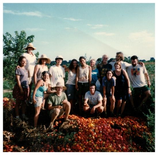 A group photo of farmers posing behind compost tomatoes.